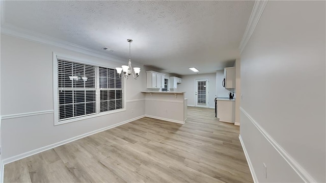 interior space featuring white cabinetry, an inviting chandelier, light hardwood / wood-style flooring, ornamental molding, and pendant lighting