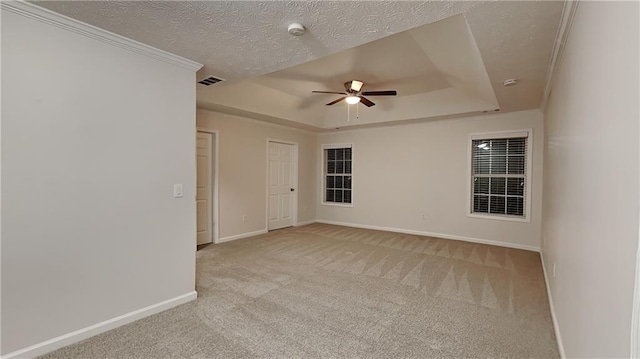 unfurnished room featuring ceiling fan, a raised ceiling, light carpet, and a textured ceiling