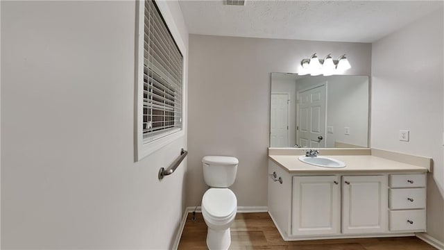 bathroom with vanity, hardwood / wood-style floors, and toilet