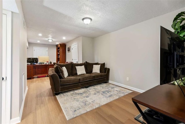 living room with light hardwood / wood-style floors and a textured ceiling