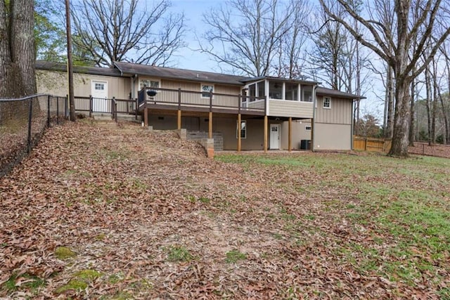 back of property with a deck and a sunroom