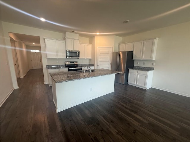 215 Barnyard Way, Perry, GA 31069 - kitchen featuring stainless steel appliances, a sink, dark wood-type flooring, white cabinetry, and dark stone countertops