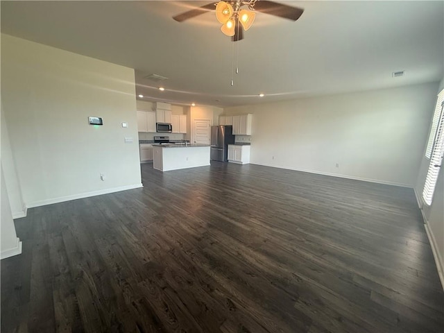 215 Barnyard Way, Perry, GA 31069 - unfurnished living room with ceiling fan, dark wood-style floors, and baseboards