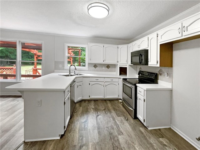 kitchen featuring a textured ceiling, hardwood / wood-style flooring, sink, white cabinetry, and appliances with stainless steel finishes