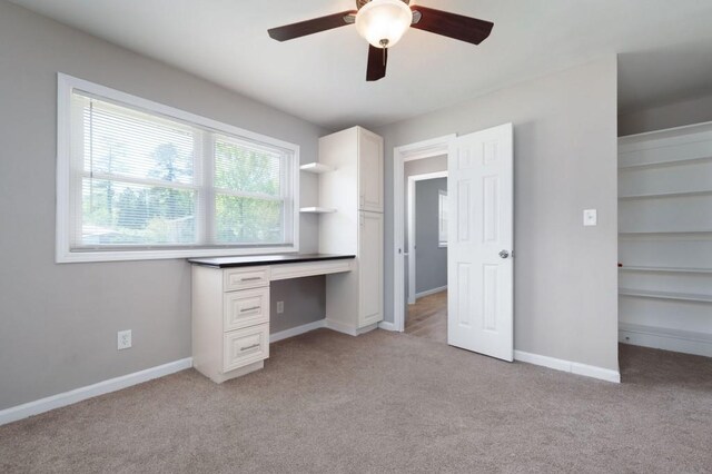 4284 Carlos Ct, Powder Springs, GA 30127 - unfurnished bedroom featuring built in desk, light colored carpet, baseboards, and a ceiling fan