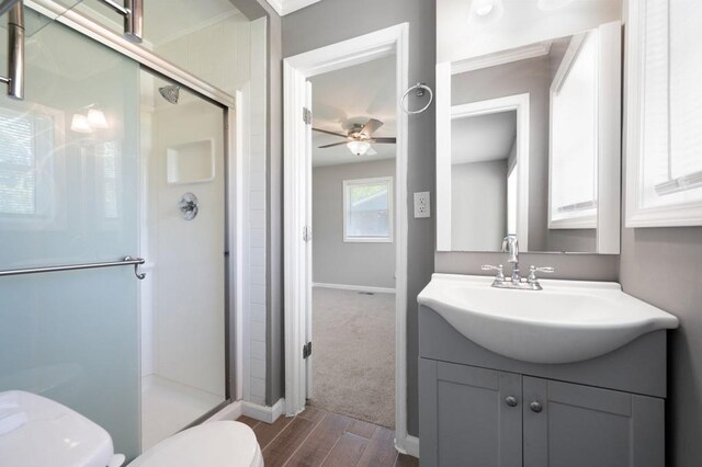 4284 Carlos Ct, Powder Springs, GA 30127 - bathroom featuring vanity, toilet, a shower stall, ceiling fan, and wood finished floors