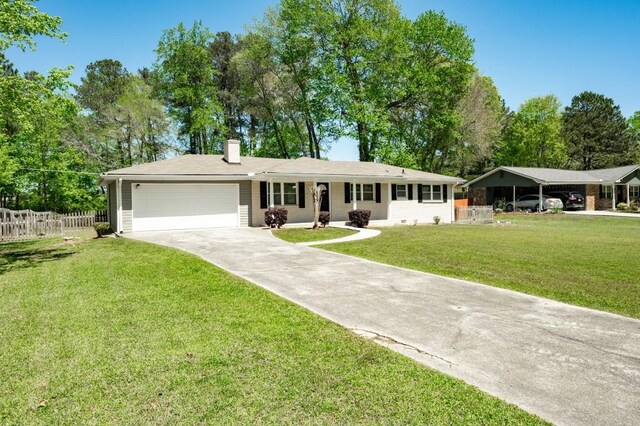4284 Carlos Ct, Powder Springs, GA 30127 - ranch-style house with a carport, driveway, an attached garage, a front yard, and fence