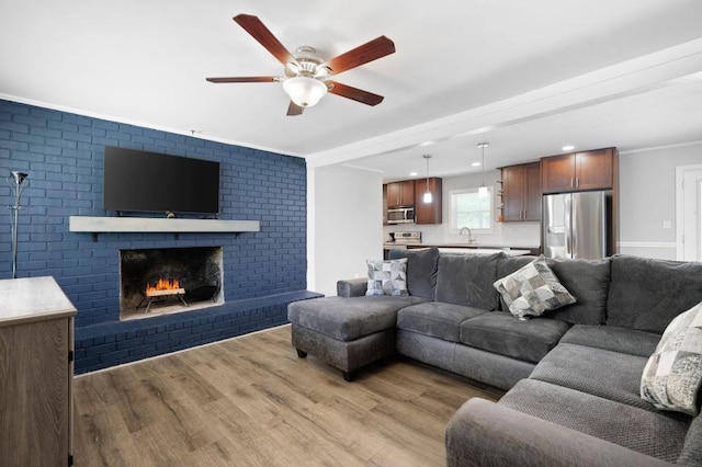 4284 Carlos Ct, Powder Springs, GA 30127 - living area featuring crown molding, light wood-type flooring, a ceiling fan, recessed lighting, and a brick fireplace