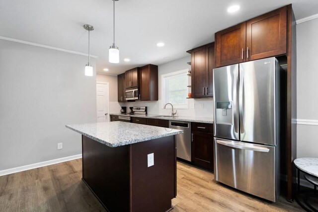 4284 Carlos Ct, Powder Springs, GA 30127 - kitchen with dark brown cabinetry, light wood-type flooring, a center island, appliances with stainless steel finishes, and a sink