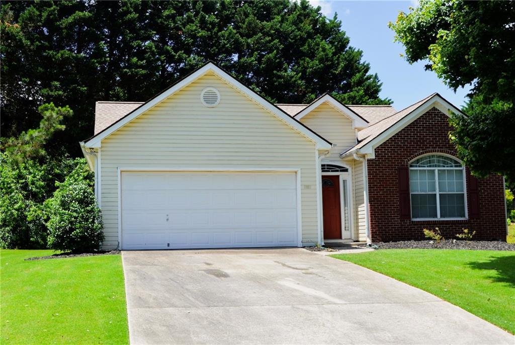 965 Under Ct, Sugar Hill, GA 30518 - view of front of property featuring driveway, an attached garage, a front yard, and brick siding