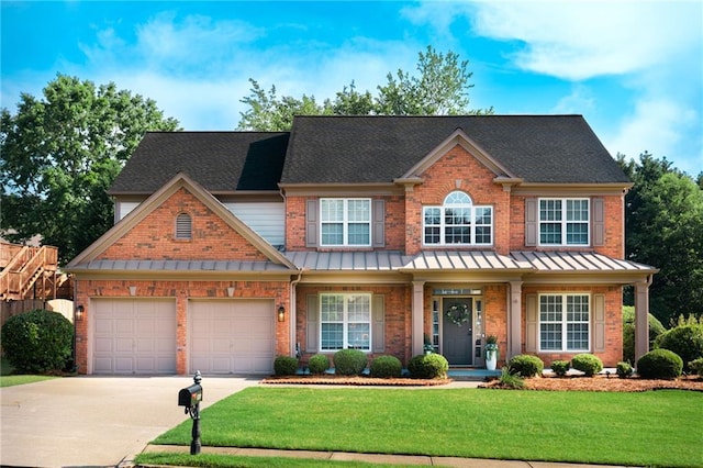 view of front facade featuring driveway, a standing seam roof, a front lawn, and brick siding
