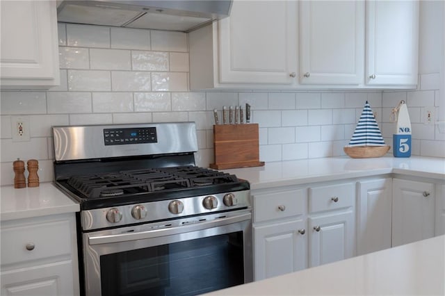 kitchen featuring stainless steel gas range, under cabinet range hood, light countertops, and white cabinets