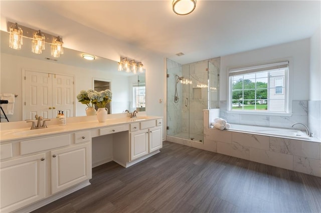 bathroom with plenty of natural light, a stall shower, a garden tub, and double vanity