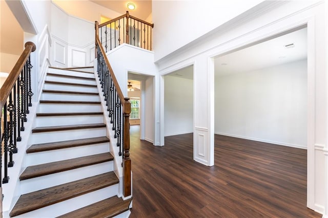 staircase featuring wood finished floors and baseboards