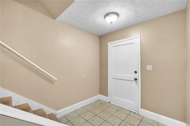 tiled foyer entrance featuring a textured ceiling