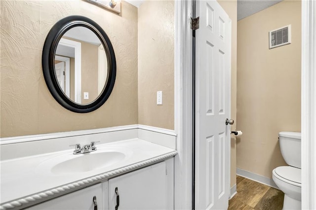 bathroom featuring hardwood / wood-style flooring, vanity, and toilet