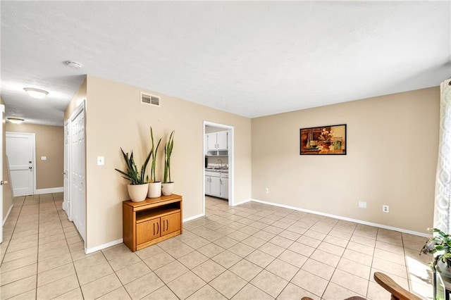 spare room with light tile patterned floors and sink