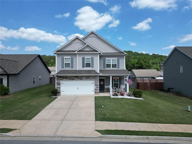 craftsman inspired home with an attached garage, concrete driveway, a porch, and a front lawn