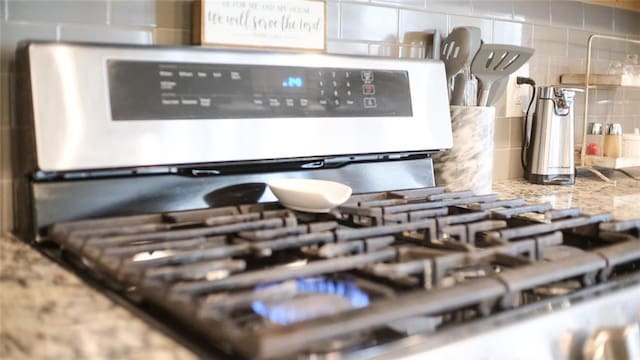 interior details with backsplash and stainless steel gas stove