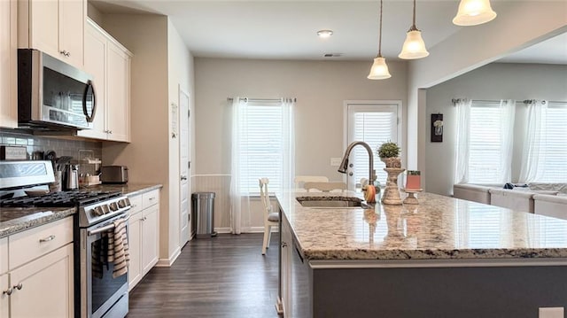 kitchen with visible vents, a sink, stainless steel appliances, white cabinetry, and dark wood-type flooring