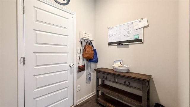 entryway featuring baseboards and dark wood-style floors