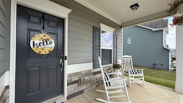 view of exterior entry featuring covered porch