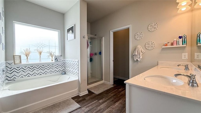 full bathroom featuring a sink, a bath, wood finished floors, and a stall shower