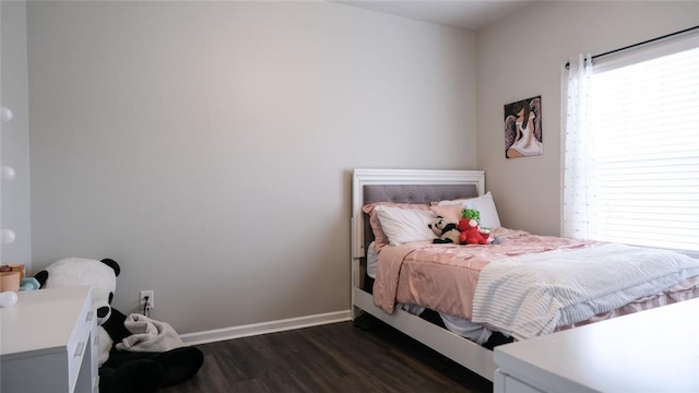 bedroom with baseboards and dark wood-type flooring