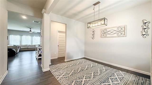 dining room with a ceiling fan, baseboards, visible vents, and dark wood-type flooring