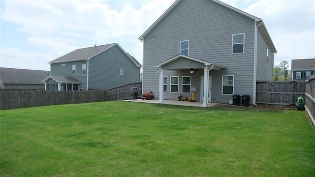 back of house with a fenced backyard, a ceiling fan, a yard, and a patio area