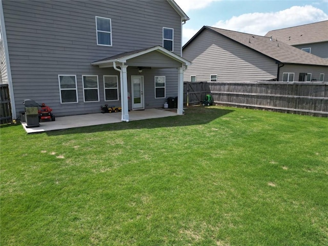 back of property featuring a yard, a patio, and a fenced backyard