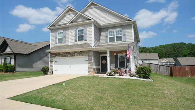 craftsman inspired home with fence, a front yard, concrete driveway, an attached garage, and a porch