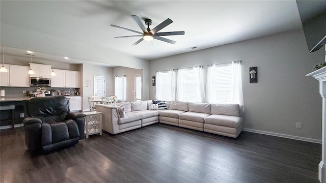 living room featuring a ceiling fan, baseboards, visible vents, and dark wood-type flooring