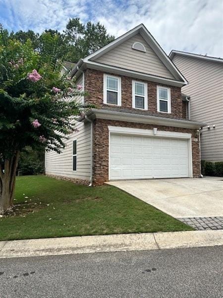 front facade featuring a garage and a front lawn