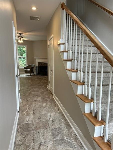 stairway featuring ceiling fan