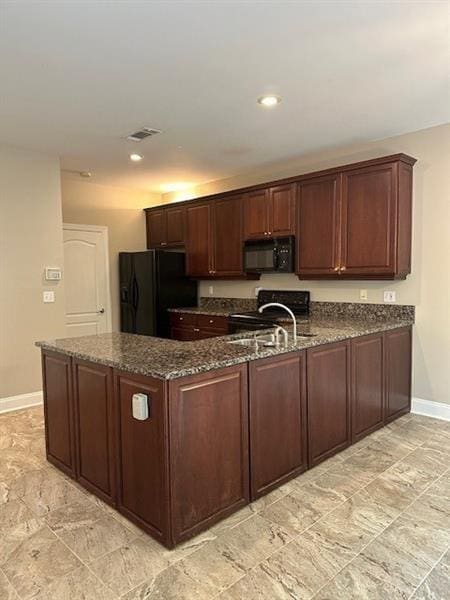 kitchen featuring dark stone countertops, sink, black appliances, and kitchen peninsula