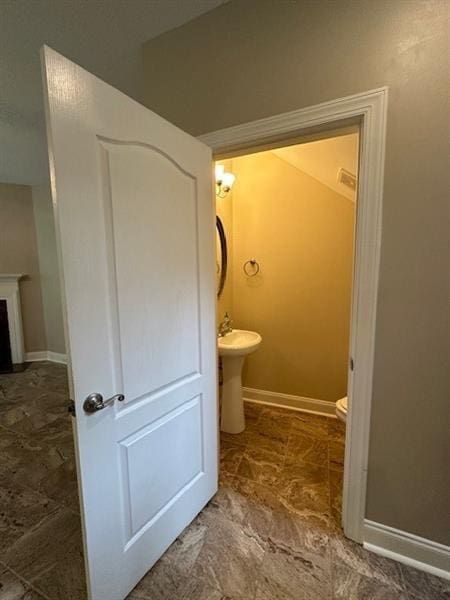 bathroom featuring a fireplace and toilet