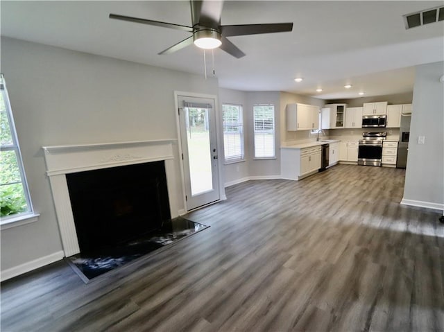 843 Kendall Park Dr, Winder, GA 30680 - unfurnished living room with dark wood-style floors, recessed lighting, a fireplace with flush hearth, and a ceiling fan