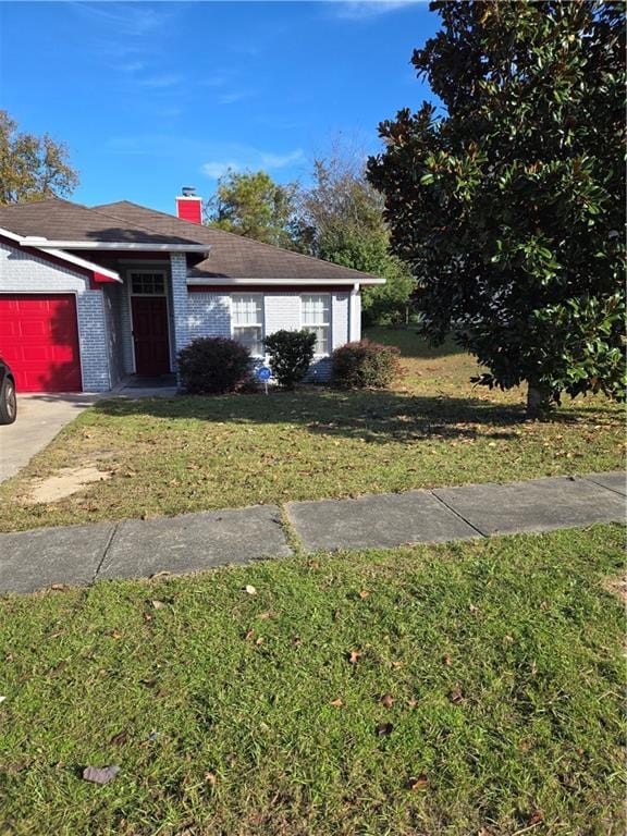 view of front of home with a garage and a front lawn