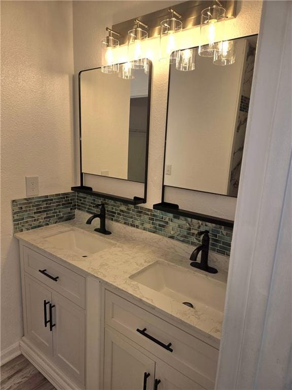 bathroom with backsplash, vanity, and wood-type flooring