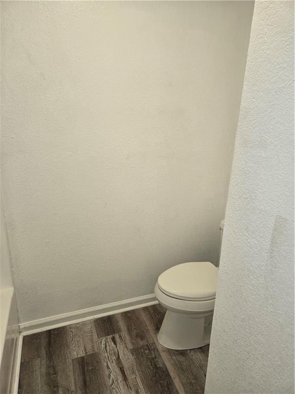 bathroom featuring wood-type flooring and toilet