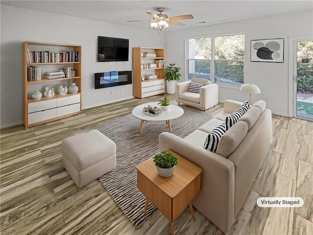 living room with light wood-type flooring and ceiling fan