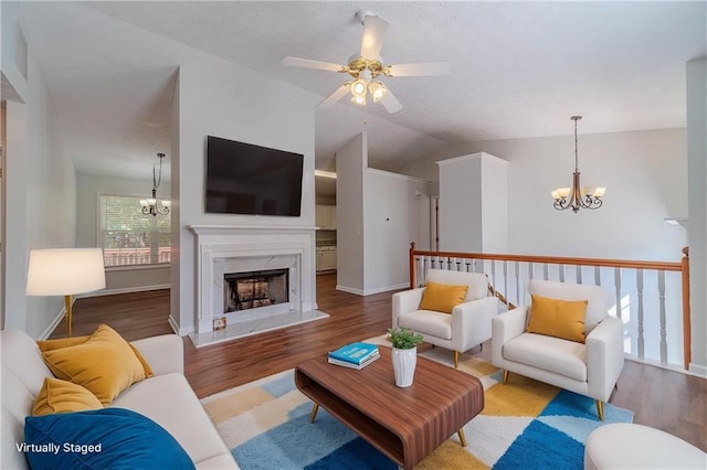 living room with a chandelier, wood finished floors, a ceiling fan, and lofted ceiling