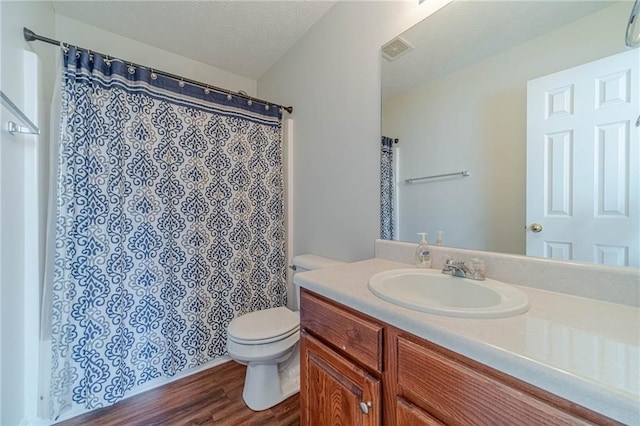 full bath with wood finished floors, toilet, vanity, a textured ceiling, and a shower with curtain