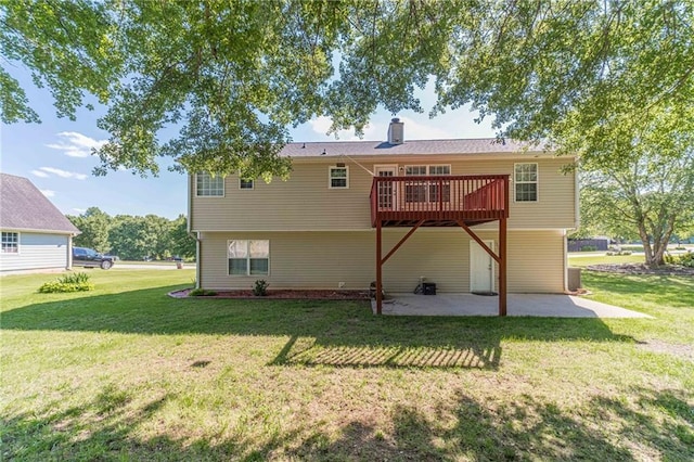 back of house with a patio area, a yard, a chimney, and a wooden deck