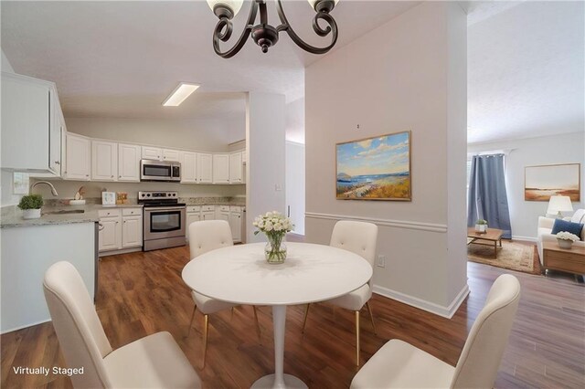 dining area with vaulted ceiling, a chandelier, dark wood-style flooring, and baseboards