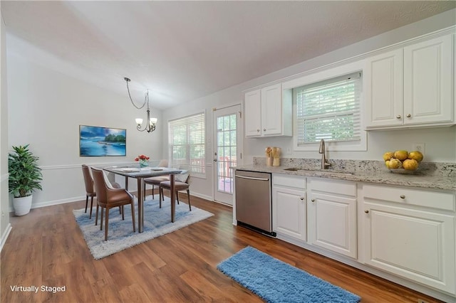 kitchen with stainless steel dishwasher, a sink, a chandelier, white cabinets, and wood finished floors