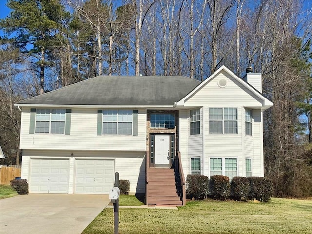 raised ranch featuring a front lawn and a garage