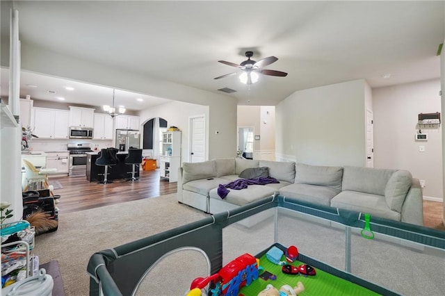 living room featuring visible vents, wood finished floors, ceiling fan with notable chandelier, carpet flooring, and recessed lighting