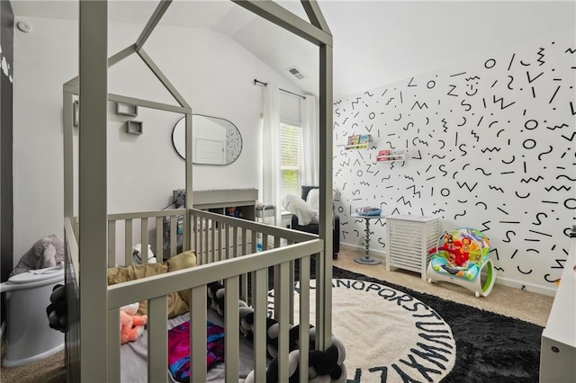 carpeted bedroom with a crib, visible vents, and vaulted ceiling